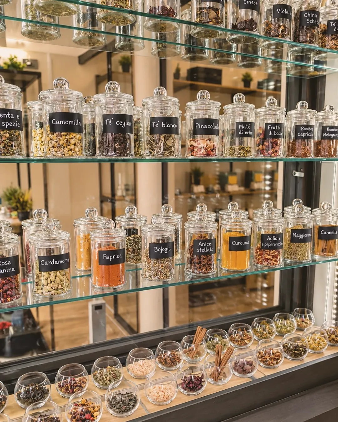 Barattoli di tè sfuso, tisane e spezie sugli scaffali di Botanicum a Trento